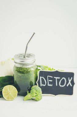Yeşil sebze suyu malzemelerle bir mason kavanoza: ıspanak, rezene, marul, kireç ve brokoli Beyaz ahşap zemin üzerinde. Bahar Detoks kavramı. Temiz yemek. Sağlıklı bir yaşam tarzı. Kopya alanı.