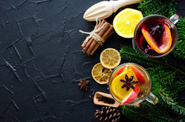 Sıcak Noel mulled şarap veya baharat ve siyah arka plan üzerine malzemeler ile gluhwein. Geleneksel içki kış tatil. İki baharatlı sıcak içecekler. Mevsimlik sıcak içecek. Uzay kopyalayın. Üstten görünüm.