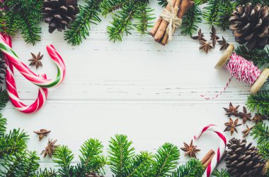 Noel çerçeve köknar ağacı dalları, doğal dekorasyon ve metin için yer beyaz zemin üzerine baston şekerler. Mutlu Noeller ve mutlu yeni yıl. Xmas kavramı. Üstten görünüm. Düz yatıyordu. Kopya alanı.