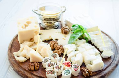 Peynir tabağı: Parmesan, kaşar peyniri, gouda, gorgonzola, brie ve diğer ceviz ve beyaz arka plan üzerinde ahşap tahta üzerinde tatlım. Lezzetli meze peynir farklı tipteki.