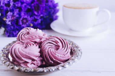 Cappuccino kahve ve Beyaz ahşap masa üzerinde mavi Peygamber buket pembe zephyr hatmi.