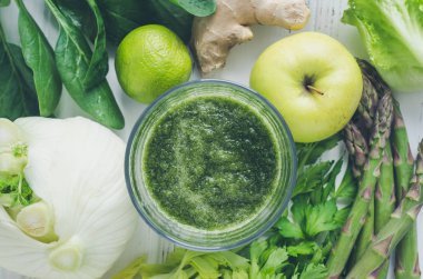 Yeşil meyve ve sebze smoothie maddeler: ıspanak, marul, rezene, kereviz, zencefil, limon, elma ve kuşkonmaz Beyaz ahşap zemin üzerinde. Bahar detoks kavramı. Sağlıklı beslenme. Üstten görünüm.