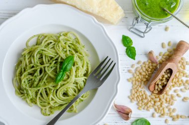 Beyaz ahşap masa üzerinde ev yapımı pesto soslu spagetti. Pesto alla Cenevizli ile makarna. İtalyan mutfağı kavramı. Üstten Görünüm.