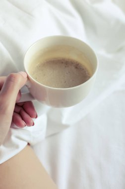 Seksi kadın yatakta sıcak cappuccino kahve fincan ile rahatlatıcı. Genç çıplak kadın güzel deri konfor rahat ev atmosfer zevk ile. Günaydın. POV.