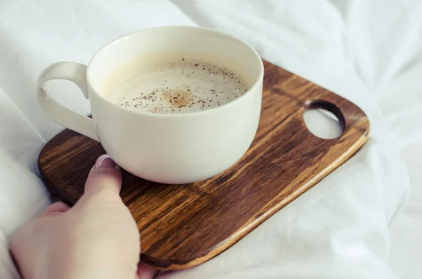 Een Kopje Koffie Vrouwelijke Hand Bed Een Witte Deken Moman — Stockfoto