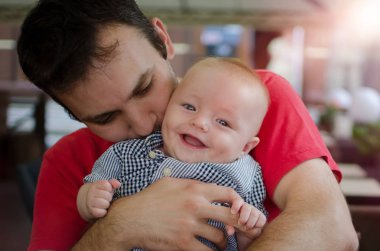 Babası sevimli gülümseyen küçük oğlu sarılmak. Mutlu babalar günü. Çocuk babasının ellerinizde. Sıcak güneşli yaz gün.