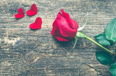 Metin için yer eski ahşap zemin üzerine kırmızı kalpler ile kırmızı gül çiçek. Romantik Sevgililer tatil kavramı. Sevgililer günü tebrik kartı. Uzay kopyalayın. Üstten görünüm.