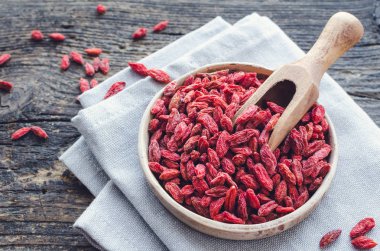 Superfood goji meyveleri ahşap arka plan üzerinde seramik kase. Sağlıklı beslenme için wolfberry. Sağlıklı süper gıda takviyesi. Alternatif Tıp. Kurtarma. Gençleşme. Zayıflama.