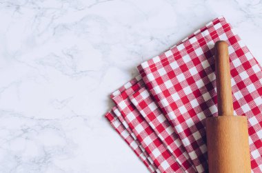 Metin için yer mermer zemin üzerine kırmızı kareli peçete üzerinde ahşap oklava. Ders poster - düzen serbest metin alanı ile yemek. Fırın kavramı arka plan. Üstten görünüm. Kopya alanı.