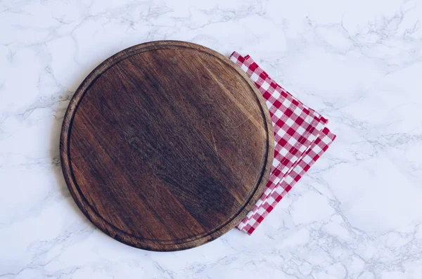 大理石桌子上的红色格子餐巾纸上空着圆形木制的切菜板 上面有文字的地方 烹饪厨房背景 顶部视图 复制空间 — 图库照片