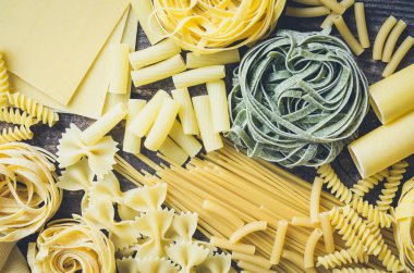 Arka plan doku çeşitli türleri ve İtalyan makarna yukarıdan eski ahşap arka plan üzerine şekiller. İtalyan mutfağı gıda kavramı ve menü tasarımı. Kuru makarna arka plan. Üstten görünüm. Düz yatıyordu.