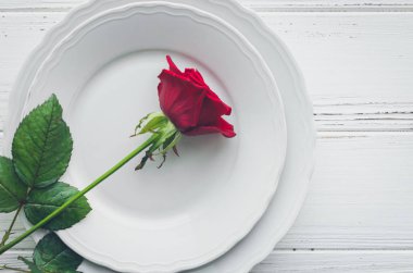 Sevgililer günü romantik tabble ayarıyla kırmızı gül, tabak, çatal bıçak takımı beyaz arka plan üzerinde. Aşk Sevgililer kavramı. Üstten görünüm. Düz yatıyordu.