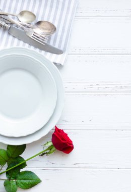 Sevgililer günü romantik tabble ayarıyla kırmızı gül, tabak, çatal bıçak takımı beyaz arka plan üzerinde. Boş levha. Mockup tasarım düzeni metniniz için. Aşk Sevgililer kavramı. Uzay kopyalayın. Üstten görünüm. Düz yatıyordu.