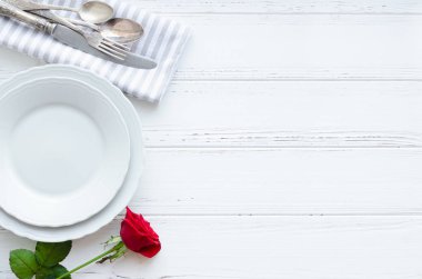 Sevgililer günü romantik tabble ayarıyla kırmızı gül, tabak, çatal bıçak takımı beyaz arka plan üzerinde. Boş levha. Mockup tasarım düzeni metniniz için. Aşk Sevgililer kavramı. Uzay kopyalayın. Üstten görünüm. Düz yatıyordu.