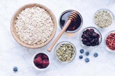 Ev yapımı granola için Malzemeler: yulaf, kenevir ve kabak çekirdeği, kızılcık ve badem, ceviz, hindistan cevizi ve agav nektar, goji çilek ve taze yaban mersini. Superfood. Üst te. Düz yatıyordu.