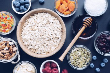 Ev yapımı granola için Malzemeler: yulaf, kabak çekirdeği, kızılcık ve badem, ceviz, hindistan cevizi ve agav nektar, taze ahududu ve yaban mersini. Superfood. Üst te. Düz yatıyordu.
