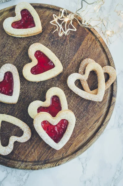 Heart shaped Linzer cookies with jam for Valentine\'s day on marble background. Delicious homemade pastry. Baking with love concept. Top view.