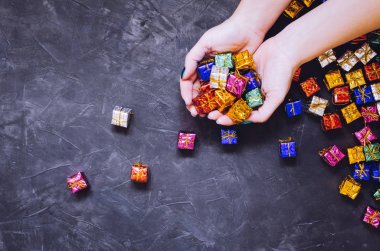 Siyah arka plan üzerinde küçük renkli hediyeler ile Kadın elleri. Renkli hediye kutuları. Online alışveriş konsepti Black Friday ve Ciber Pazartesi. Kopya alanı. Üst te. Düz yatıyordu.