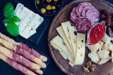 Akdeniz mezeleri, tapas ya da antipasto dolu bir masa. Çeşitli İtalyan yemek takımları. Partide ya da piknikte lezzetli atıştırmalıklar. Et ve peynirli kıyma tahtası. İtalyan usulü ziyafet. Üst görünüm.