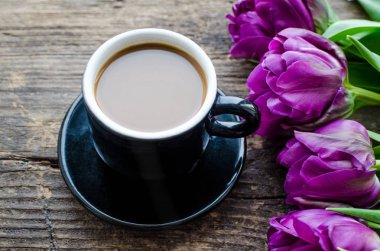 Kahve ve çiçek lale. Eski rustik ahşap masa üzerinde kahve ve mor lale fincan. Anneler günü, Sevgililer Günü veya Kadınlar günü kahvaltı. Bahar arka planı.