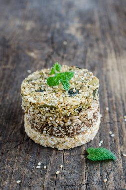 Tatlı mısır gevreği aperatifler. Fitness diyet yiyecek. Kozinaki susam, yer fıstığı, ayçiçeği ve kabak çekirdeği ve çikolatalı eski rustik ahşap Yönetim Kurulu, nane yaprağı. Vejetaryen Sağlıklı beslenme kavramı.