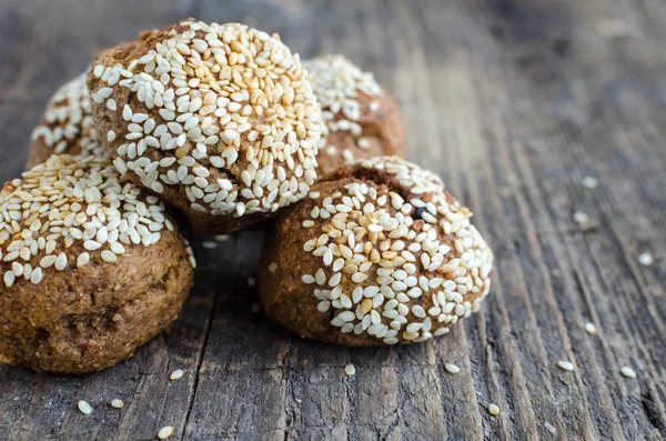 Sweet dessert cereal snacks. Fitness dietary food. Banana-oatmeal cookies with honey and a sprinkled sesame seeds on old rustic wooden board. Vegetarian-vegan healthy nutrition concept. Copy space.