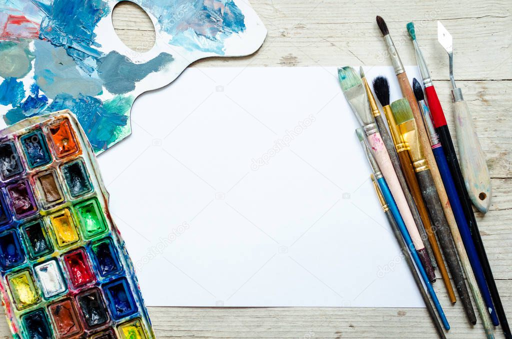 Artist paint brushes on the wooden background