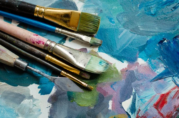 Ahşap palet üzerinde sanatçı boya fırçaları — Stok fotoğraf