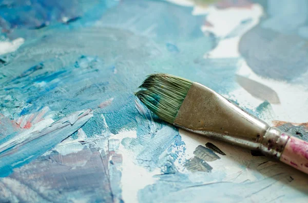 Ahşap palet üzerinde sanatçı boya fırçası — Stok fotoğraf