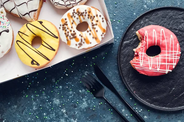 Pink frosted donut on dark background