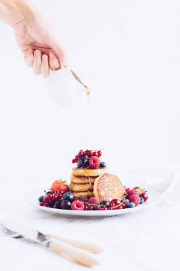 Lezzetli kreplere akçaağaç pekmezi döken kadın.