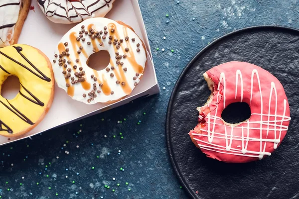 Pink frosted donut on dark background