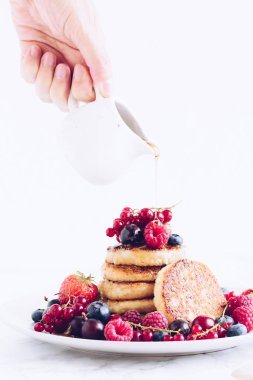 Lezzetli kreplere akçaağaç pekmezi döken kadın.