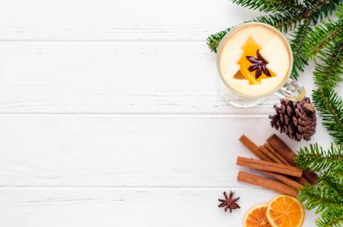 Noel şarabı, portakallı beyaz şaraba dayanır ve Noel ağacı ile süslenir. Elmadan, beyaz ahşap arka planda, baharatlı. Mevsimlik ve tatiller. Üst Manzara. Düz yatıyordu. Boşluğu kopyala.