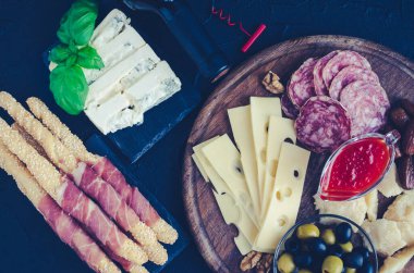 Akdeniz mezeleri, tapas ya da antipasto dolu bir masa. Çeşitli İtalyan yemek takımları. Partide ya da piknikte lezzetli atıştırmalıklar. Et ve peynirli kıyma tahtası. İtalyan usulü ziyafet. Üst görünüm.