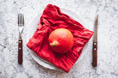 Şükran Günü sonbahar sofra takımı ve güz yaprakları ve gri arka planda balkabağı düzenlemesi. Şükran Günü tatili konsepti. Üst görünüm.