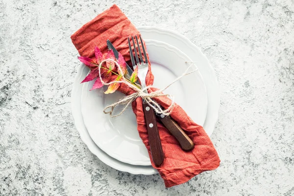 Şükran Günü sonbahar sofra takımı ve gri arka planda sonbahar yaprakları. Şükran Günü tatili konsepti. Üst görünüm.