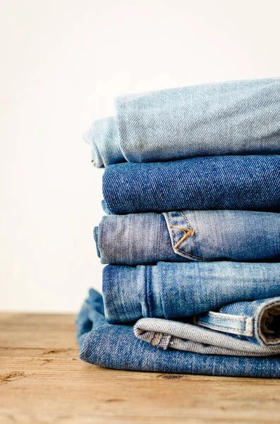 Jeans Empilhados Uma Mesa Madeira Denim Têxteis Vestuário Conceito Pilha — Fotografia de Stock