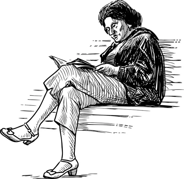 Yaşlı bir kadın bir parkta bankta bir kitap okuma taslağını