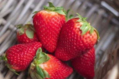 Tahta bir sepetin içindeki olgun organik çilekleri kapat.