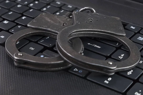Çelik polis kelepçe dizüstü simyoliziruya klavyede Siber Suçlar karşı bir mücadele yalan.