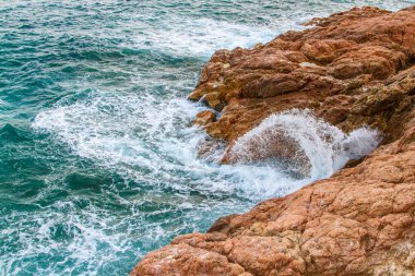 Gelgit geçişli. Köpüklü mavi dalgalar çökmesini kıyı uçurumlarda