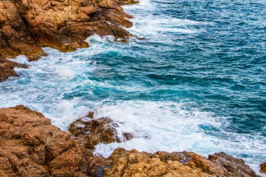 Gelgit geçişli. Köpüklü mavi dalgalar çökmesini kıyı uçurumlarda