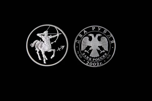 Silver coin of the Bank of Russia with the sign of the zodiac Sagittarius on a black isolated background. The coin says: \