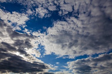 Yırtık beyaz bulutlarla kaplı derin mavi gökyüzü