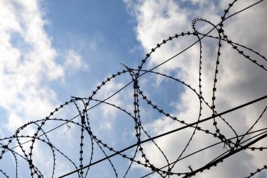 Dikenli tel bir bulutlu gökyüzü karşı