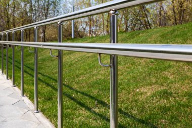 Yeşil çim bir arka plan karşı paslanmaz çelik çit ayrılması