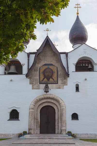 白色石头教堂的立面碎片 有拱形入口和黑色圆顶 入口上方是耶稣基督的脸 — 图库照片