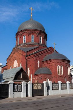 Siyah kubbeli eski ortodoks kırmızı tuğla kilise bir taş çit ile çevrili