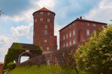 Yuvarlak kulesi ve taş kapıları olan antik tuğladan bir kale.